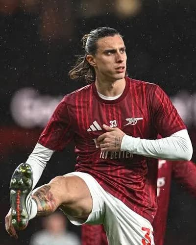 Jugador de Arsenal realizando estiramiento en campo