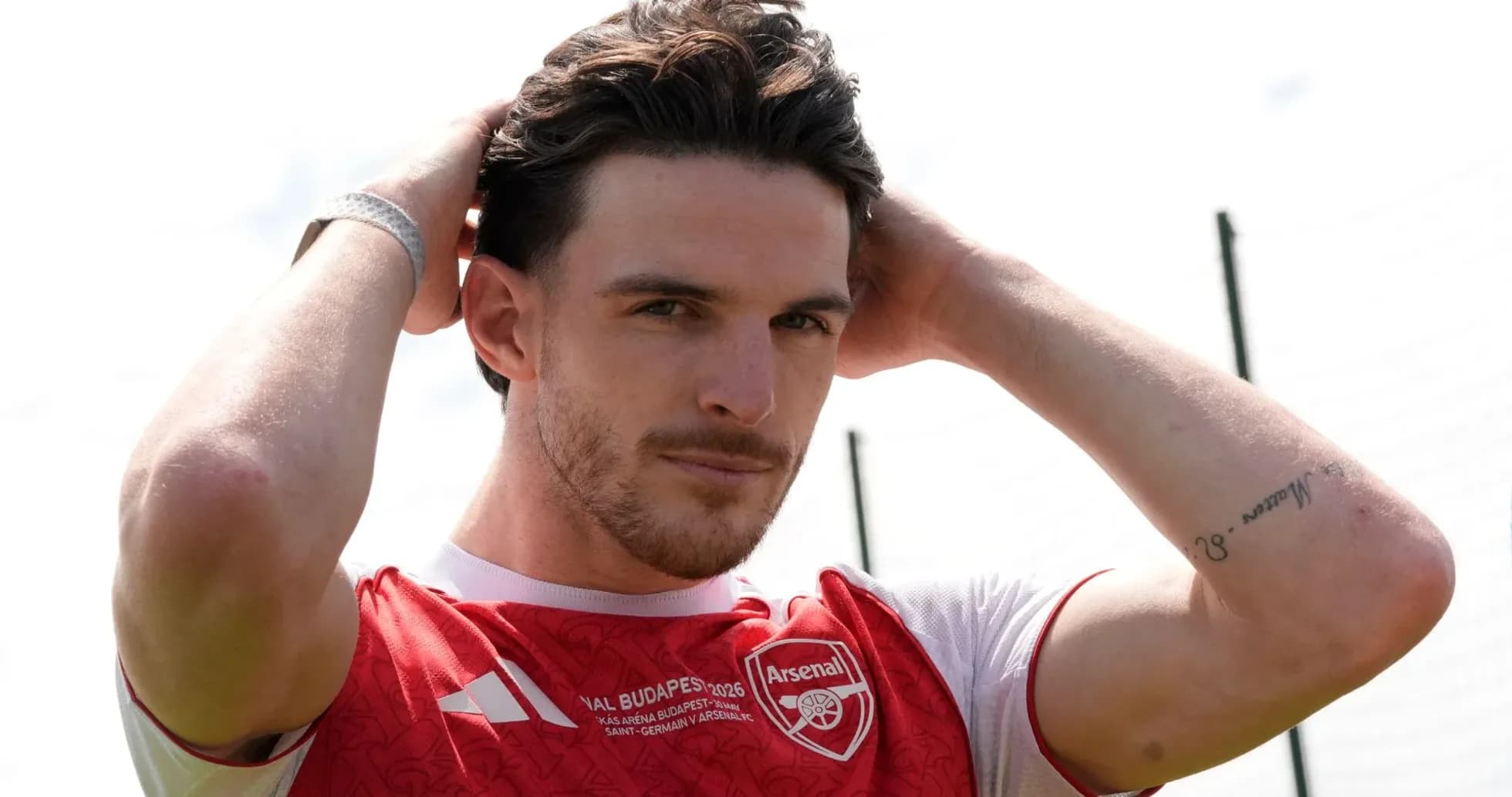 Jugador de Arsenal ajustando su cabello en el campo