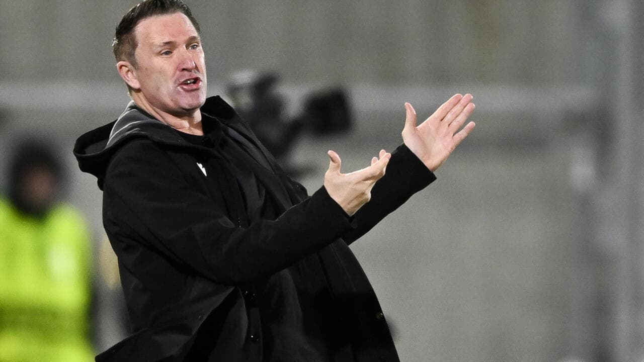 Entrenador gesticulando en la línea de banda