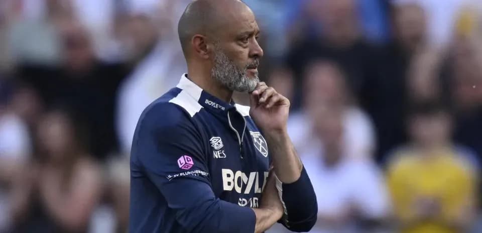 Entrenador observando el partido con expresión pensativa