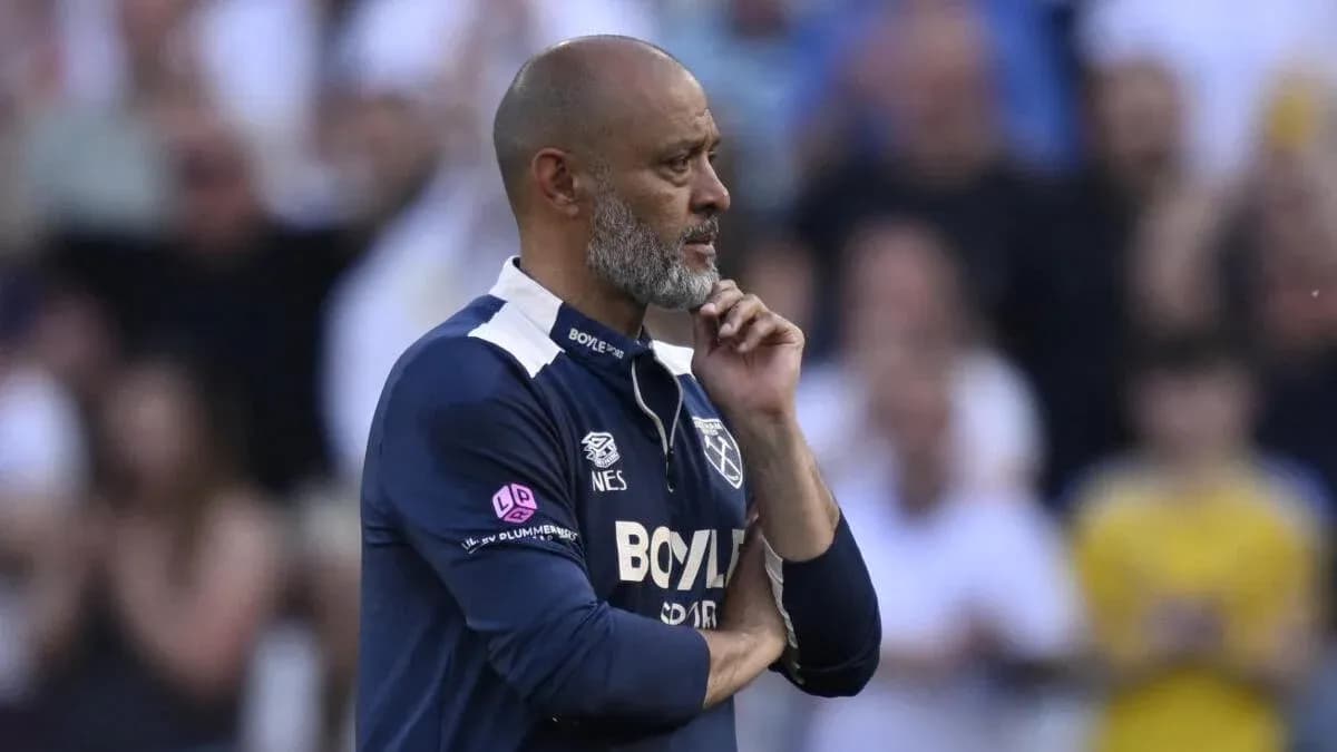 Entrenador observando el partido con expresión pensativa
