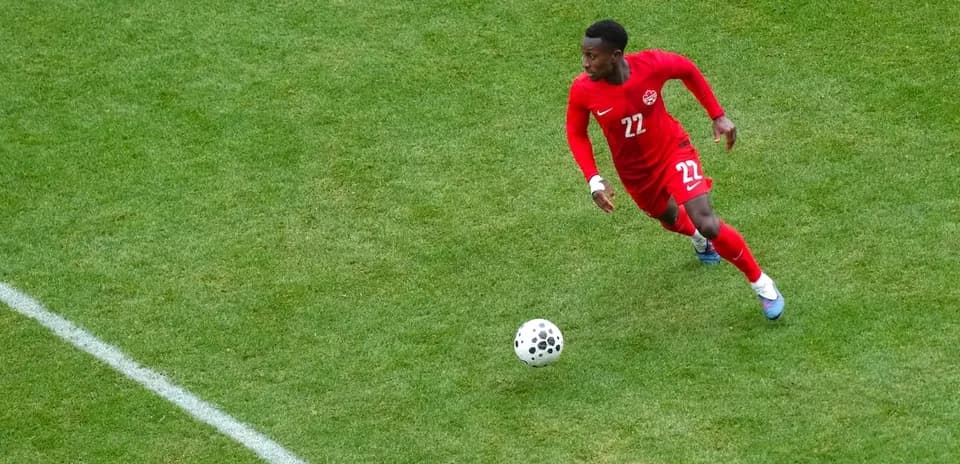 Jugador corriendo con el balón en partido