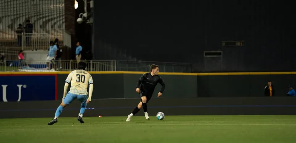 Jugador corriendo con el balón en el campo