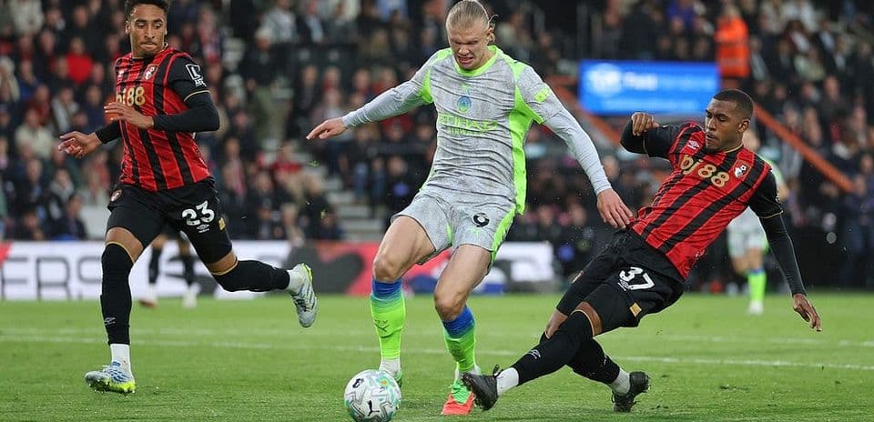 Erling Haaland driblando entre dos jugadores de Bournemouth
