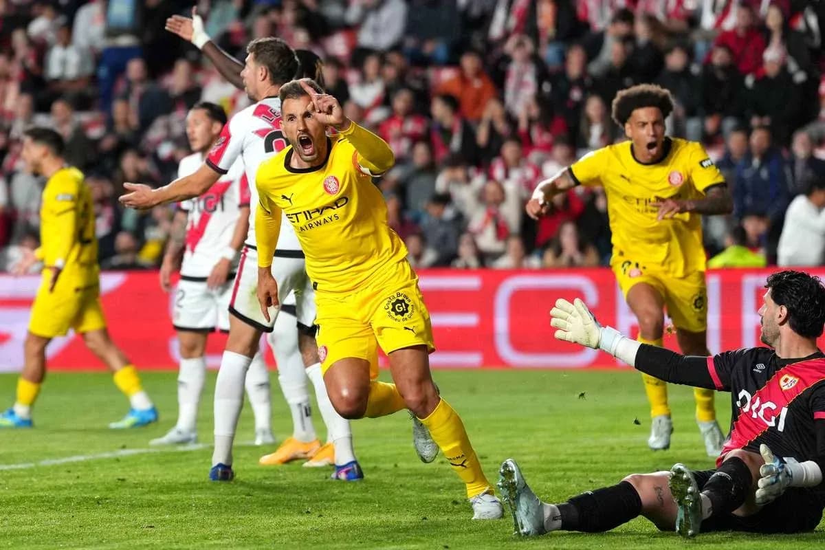 Jugador celebrando un gol mientras el portero observa