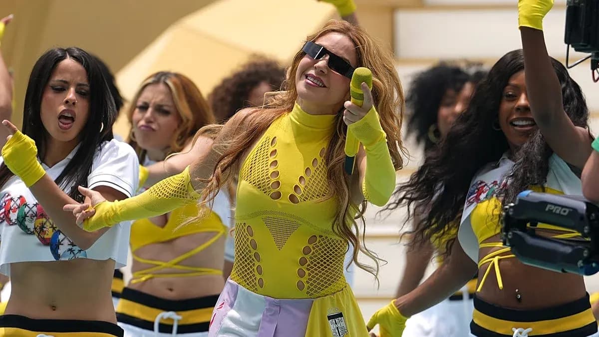 Artista actuando con bailarinas en coreografía colorida