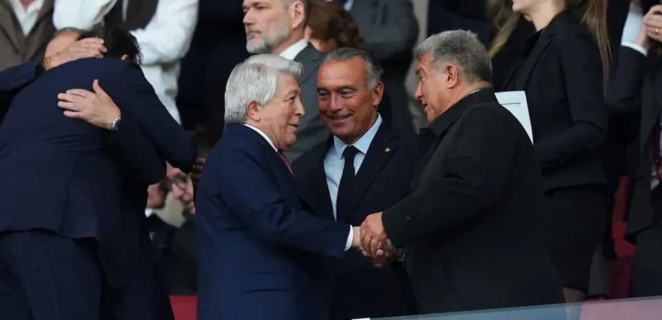 Tres personas estrechándose la mano en el palco