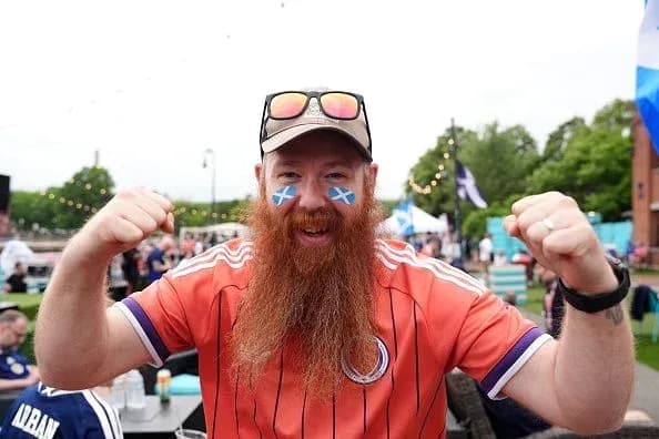 A fan celebrating with a Scottish flag face paint