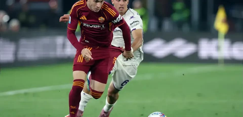 Jugador de Roma corriendo con el balón, rival persiguiéndolo