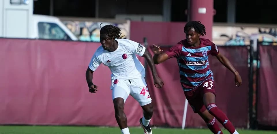 Dos jugadores corriendo detrás del balón
