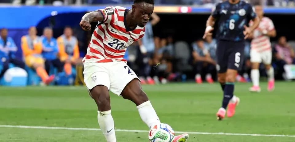 Jugador estadounidense despejando el balón en partido