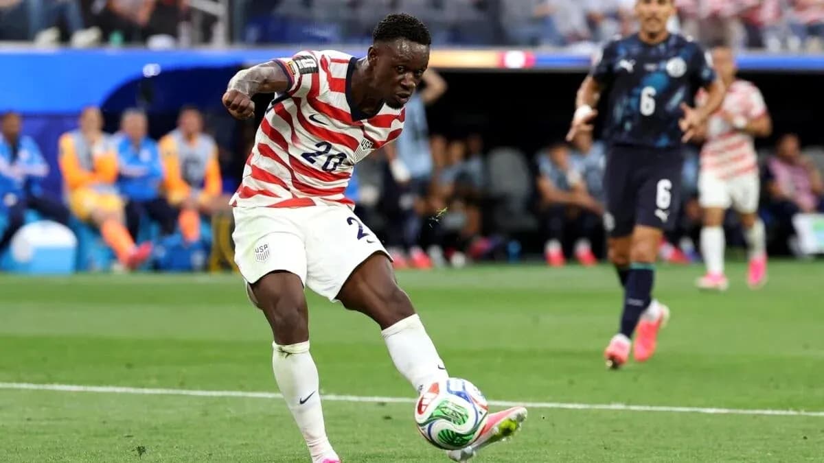 Jugador estadounidense despejando el balón en partido