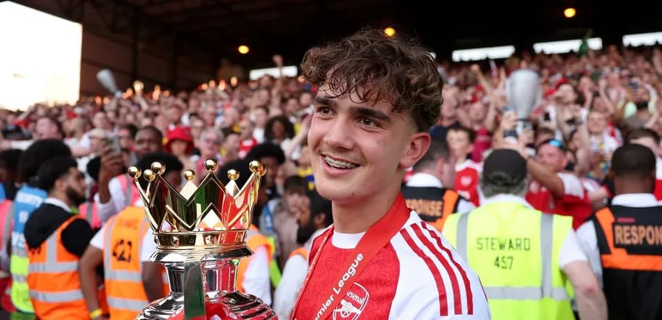 Jugador del Arsenal celebrando con el trofeo de la Premier League