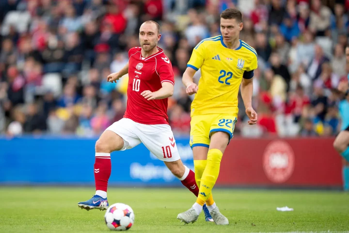 Jugador danés y ucraniano compitiendo por el balón