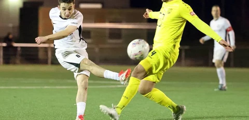 Jugador dispara a portería en partido de fútbol