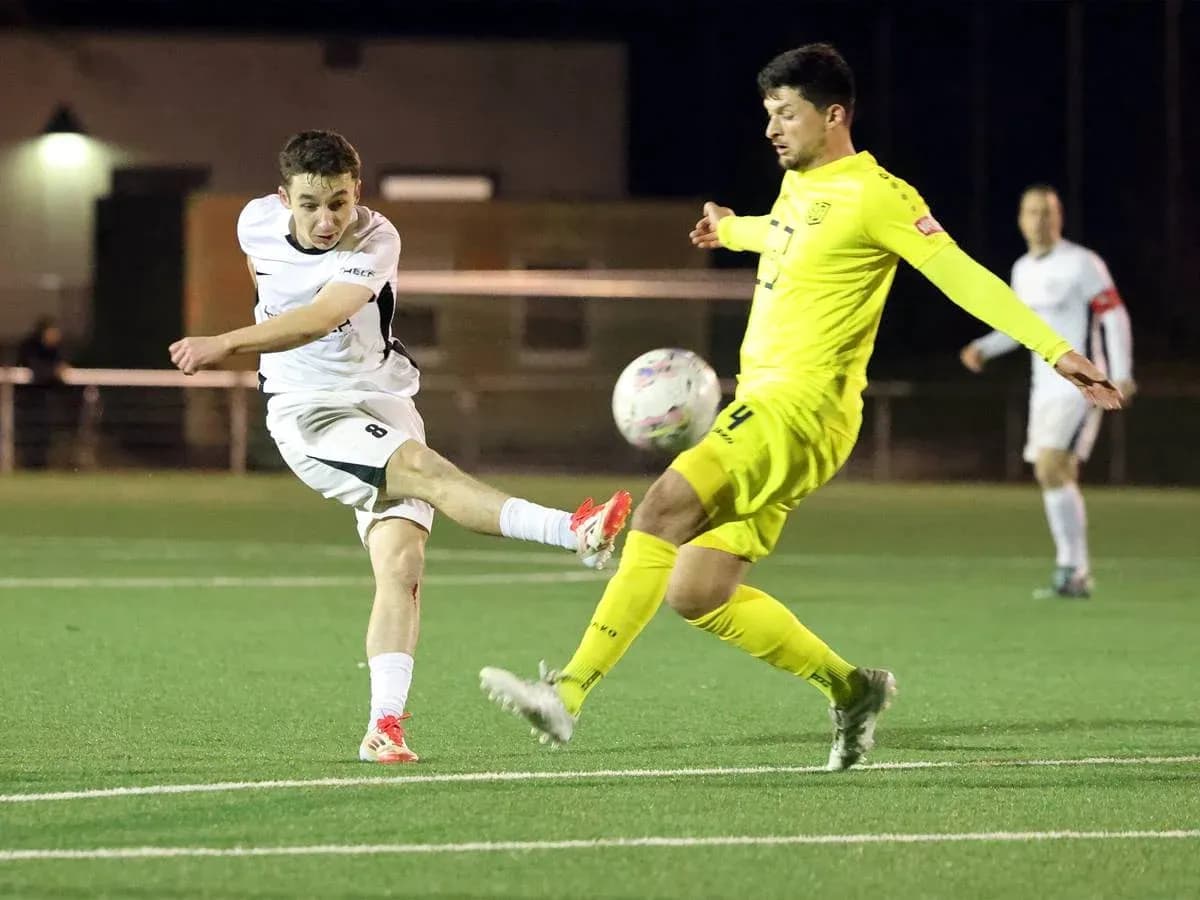 Jugador dispara a portería en partido de fútbol
