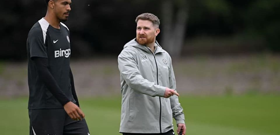 Jugador y entrenador conversando en el campo de entrenamiento
