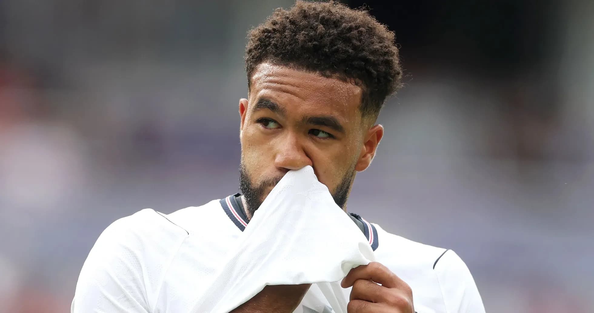 Jugador sosteniendo su camiseta durante el partido
