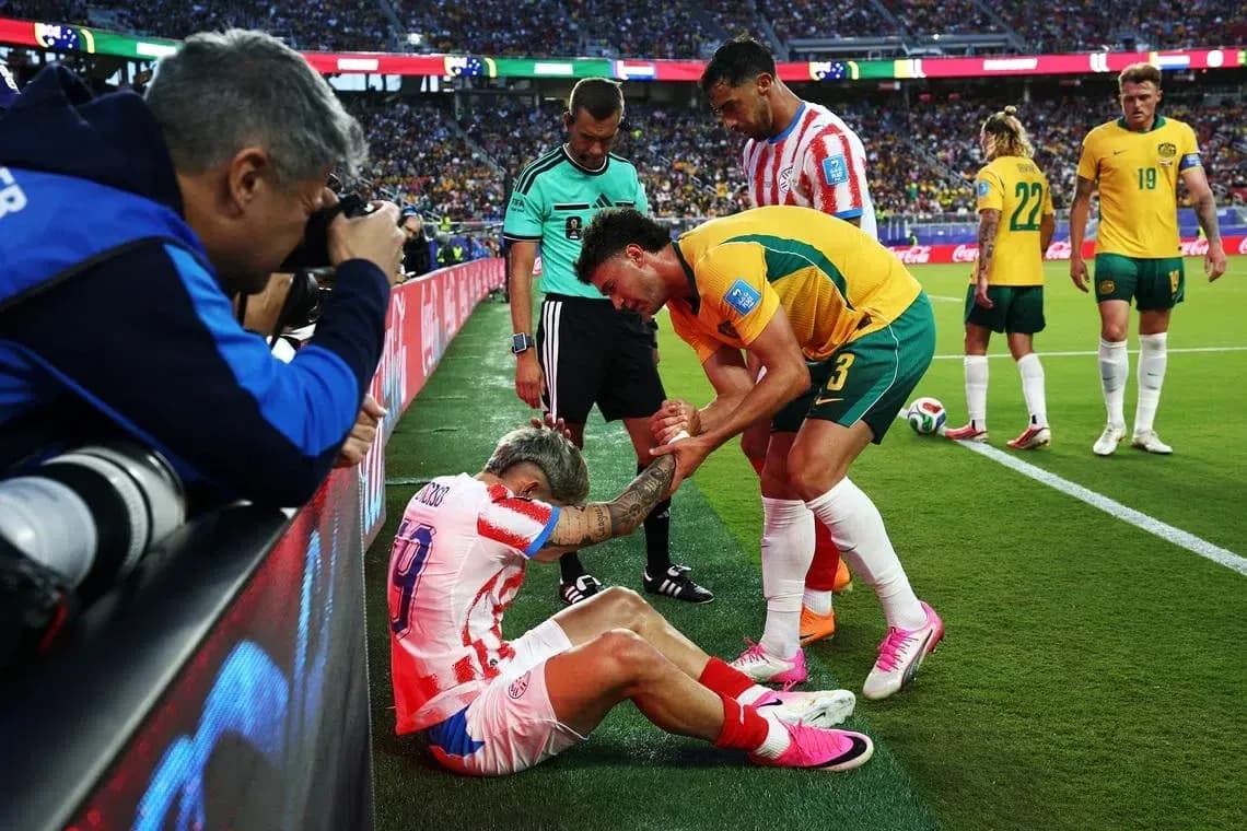 Jugador caído siendo asistido por oponente y árbitro