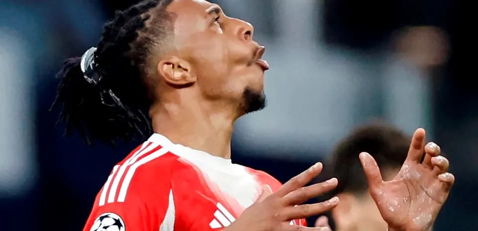 Jugador con camiseta roja mirando hacia arriba en el campo