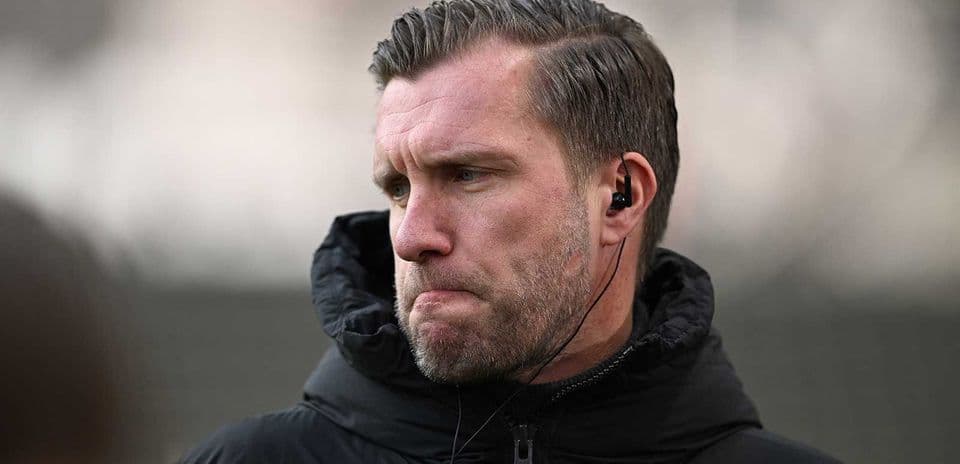 Entrenador escuchando con auriculares en el campo