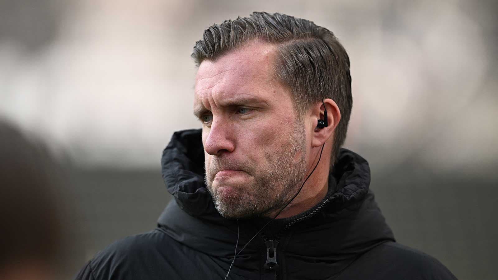 Entrenador escuchando con auriculares en el campo