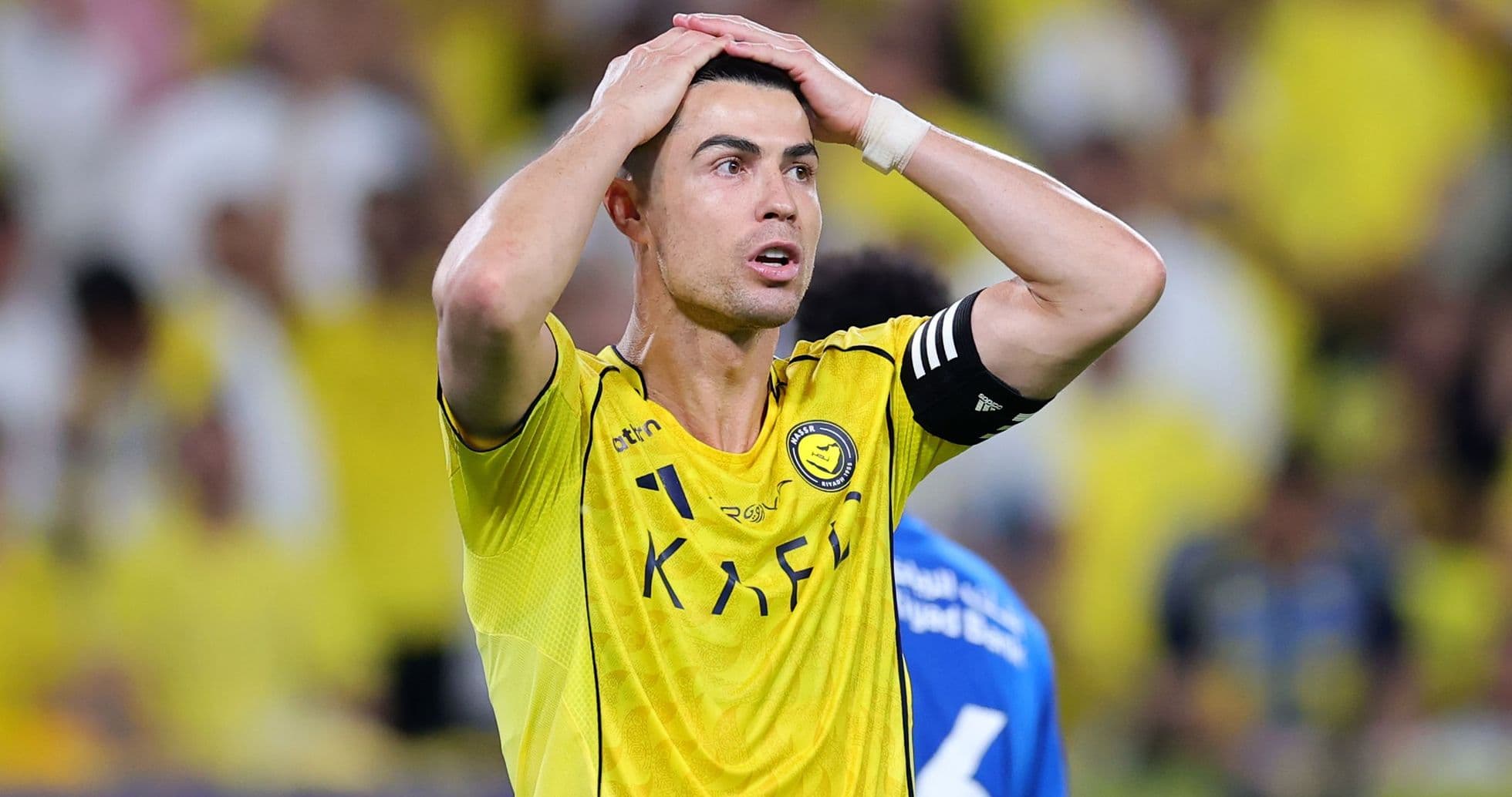 Jugador con camiseta amarilla sosteniendo la cabeza