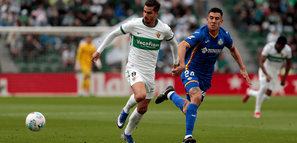 Jugadores de Elche y Getafe luchando por el balón