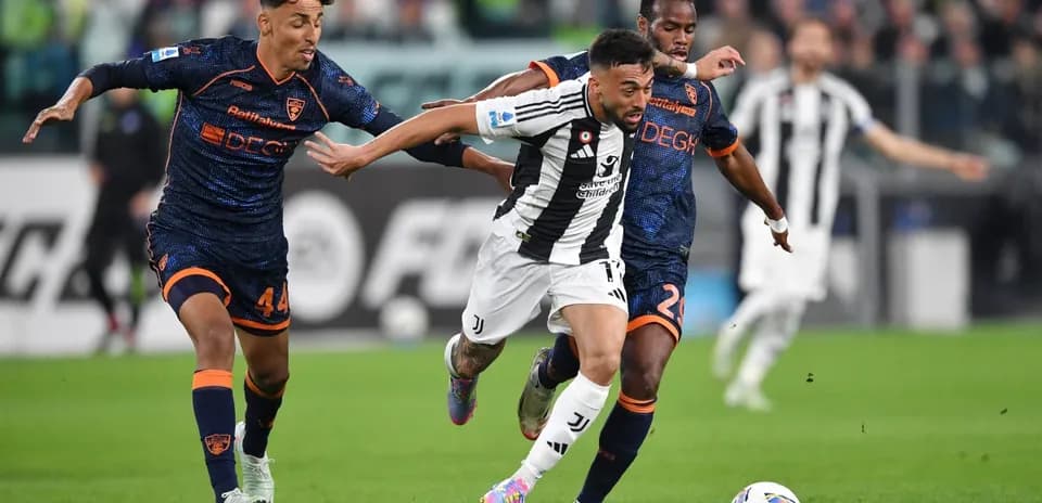 Jugador de Juventus driblando entre dos defensores