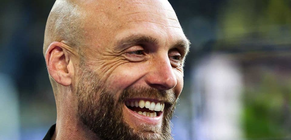 Hombre sonriente con barba en un evento