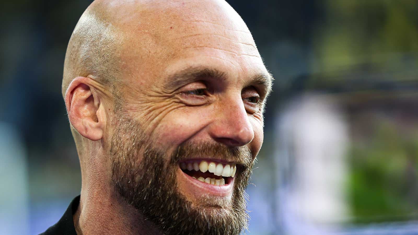 Hombre sonriente con barba en un evento