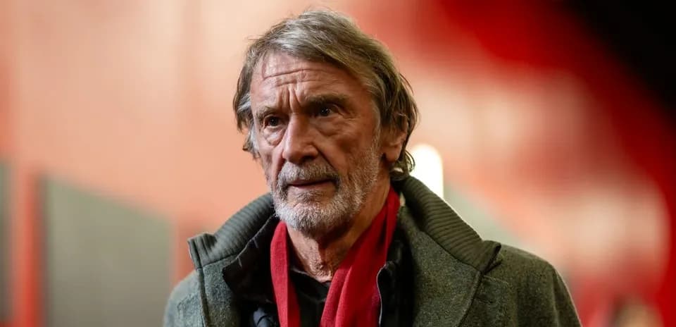 Hombre con abrigo y bufanda roja en pasillo