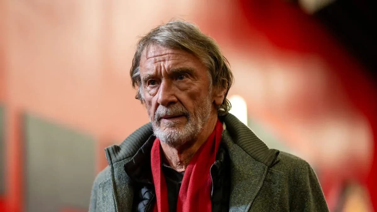 Hombre con abrigo y bufanda roja en pasillo