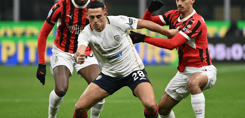 Jugador de Cagliari en acción contra defensores de AC Milan