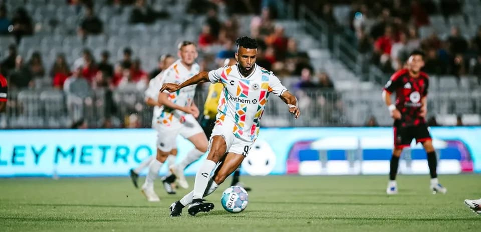 Jugador corriendo con el balón en el partido