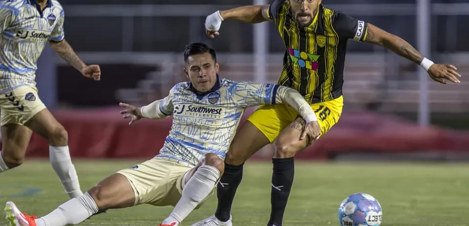 Dos jugadores compiten por el balón en el partido