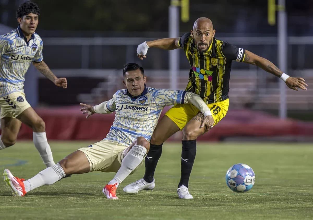 Dos jugadores compiten por el balón en el partido