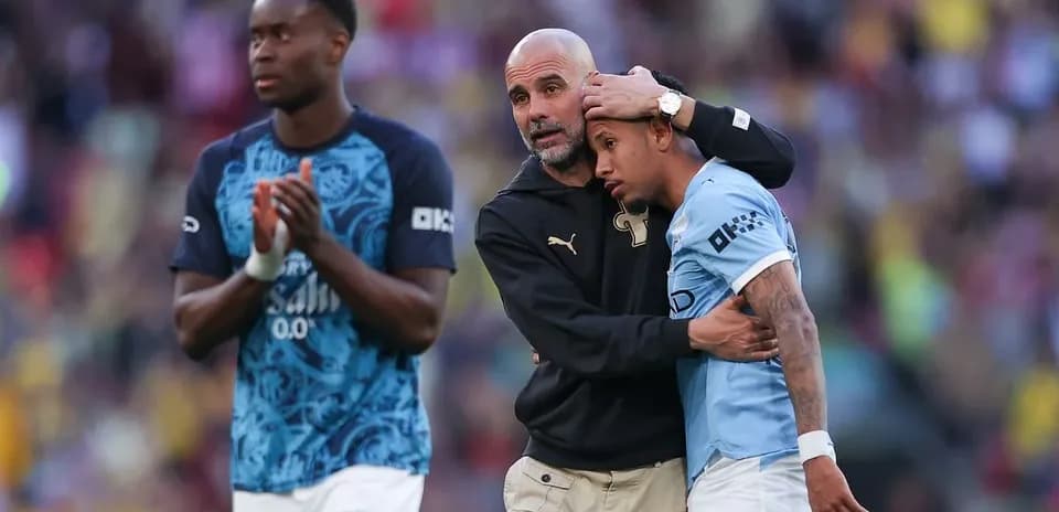 Pep Guardiola consolando a un jugador de Manchester City