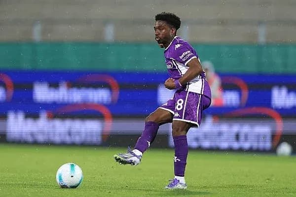 Jugador de fútbol en acción durante partido lluvioso