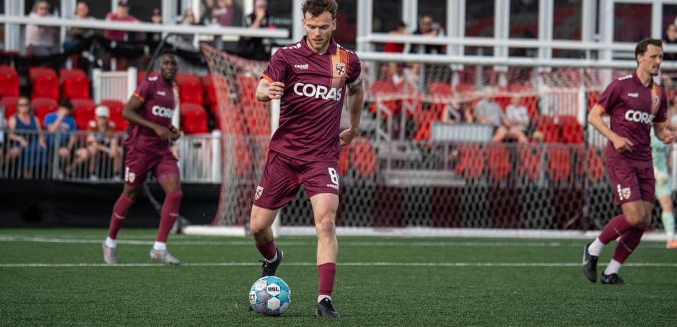 Jugador corriendo con el balón en el campo