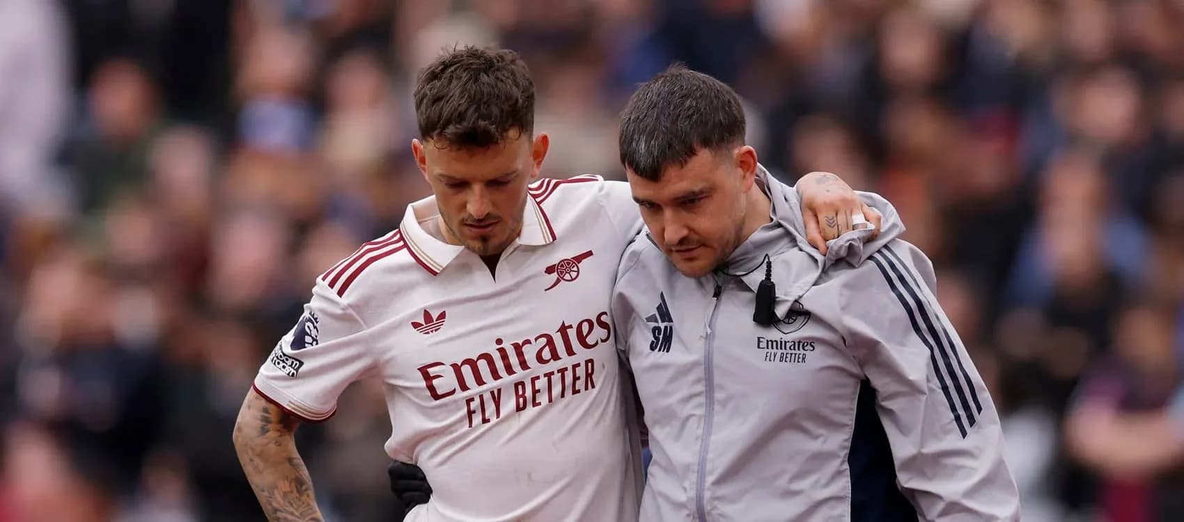 Jugador de Arsenal siendo ayudado por el personal médico