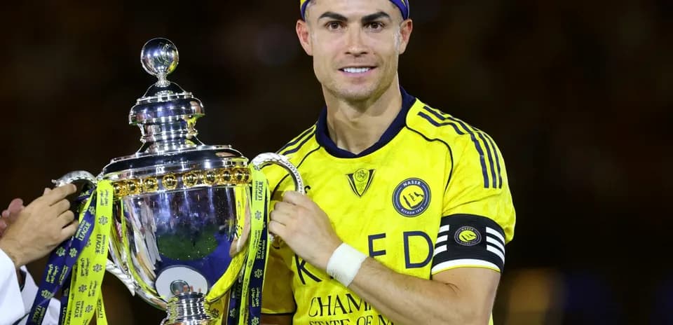 Jugador sosteniendo trofeo con camiseta de Al Nassr