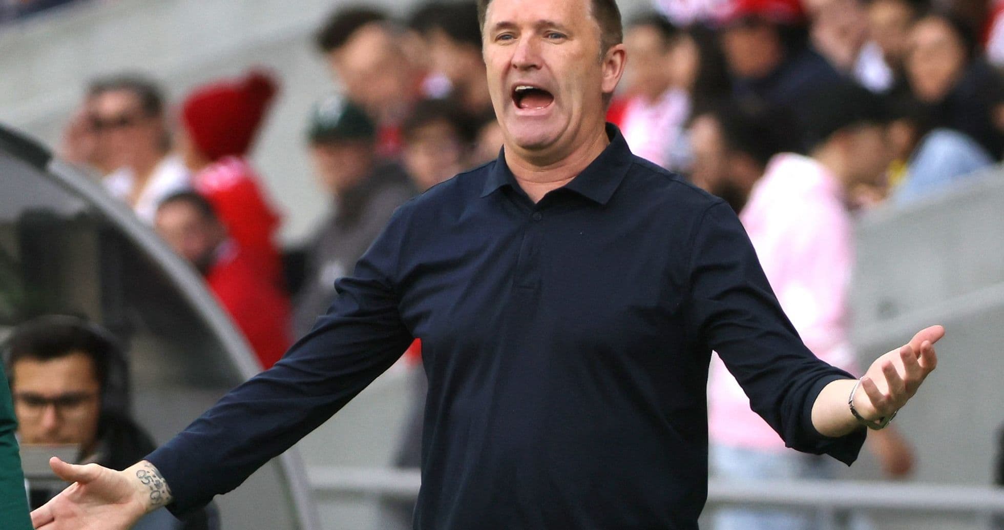 Entrenador gesticulando durante un partido de fútbol