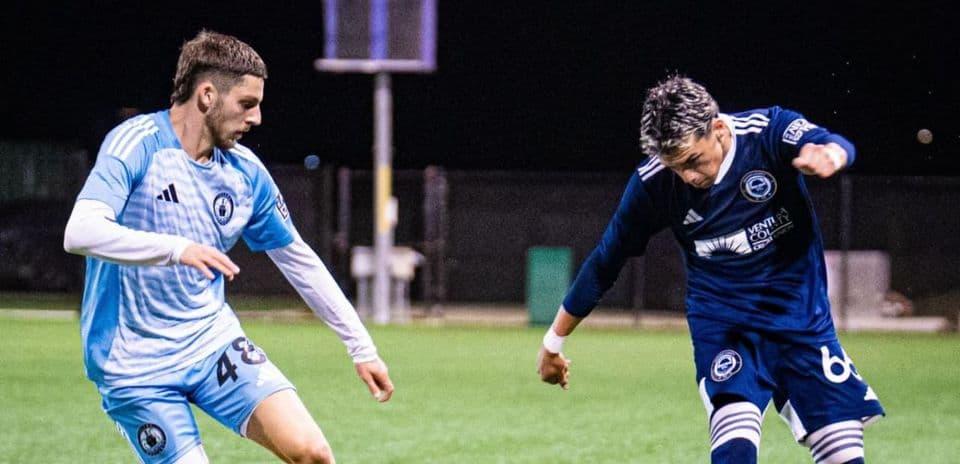 Dos jugadores compitiendo por el balón en fútbol