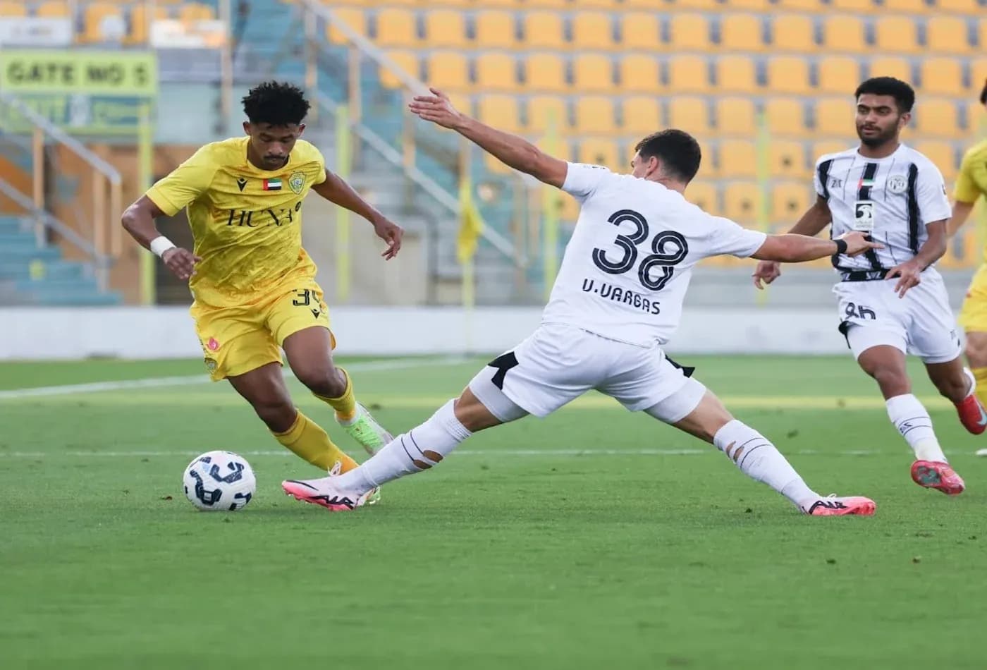 Jugador driblando en partido de fútbol U23
