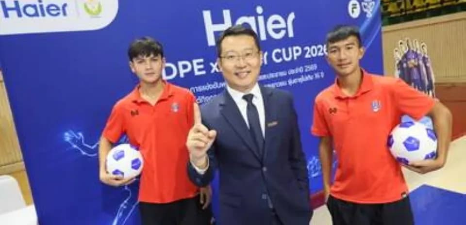 Dos jugadores sosteniendo balones de fútbol con un representante