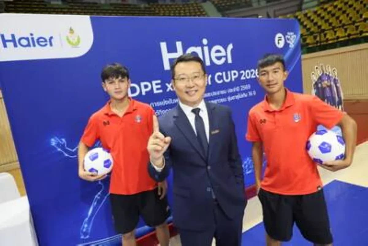 Dos jugadores sosteniendo balones de fútbol con un representante