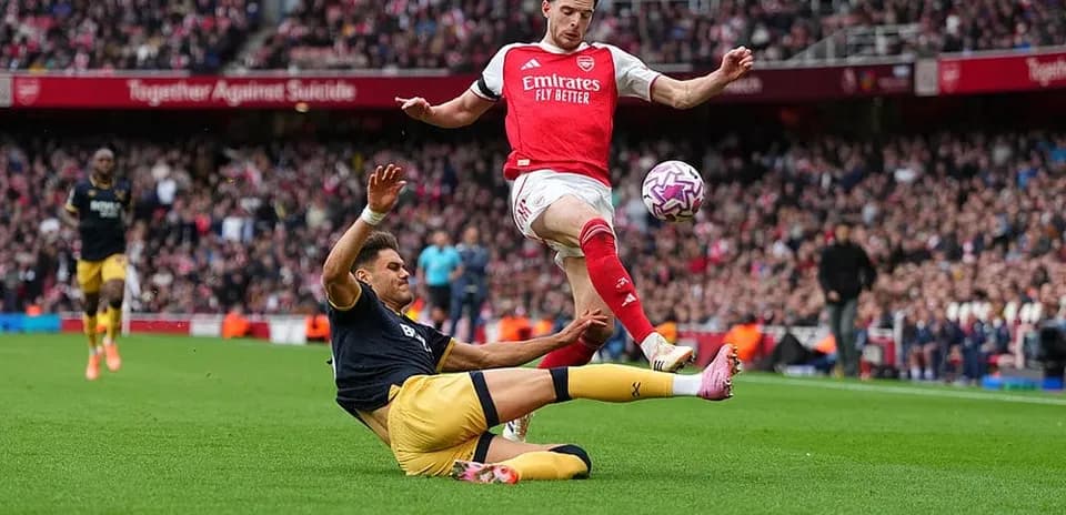 Jugador de Arsenal saltando sobre un oponente