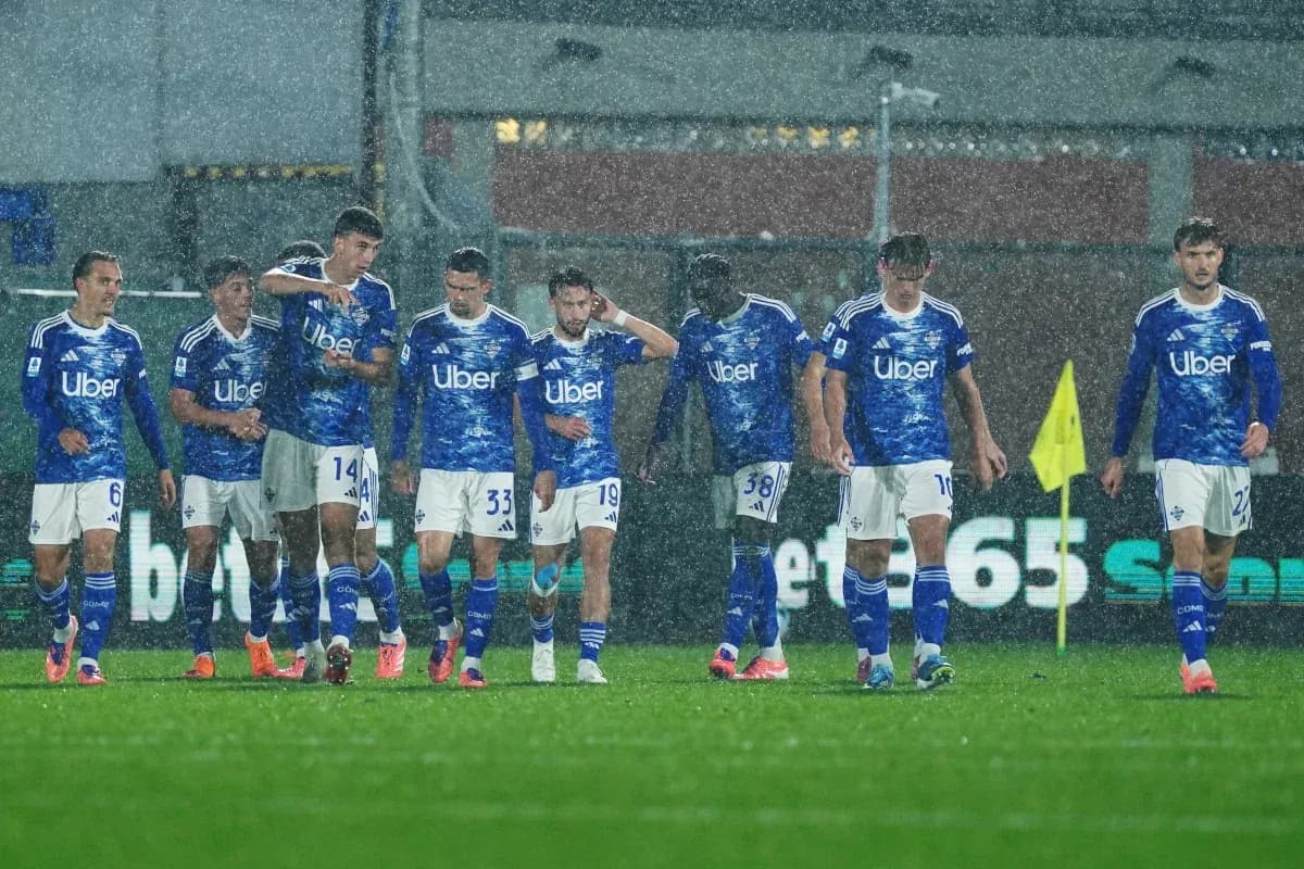 Equipo de Como en partido de fútbol bajo la lluvia
