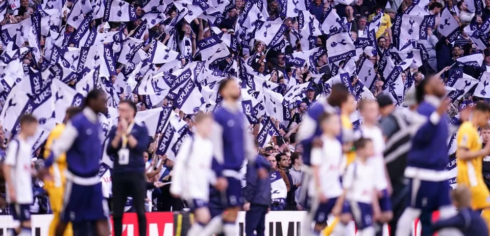 Aficionados agitando banderas de Tottenham en el estadio